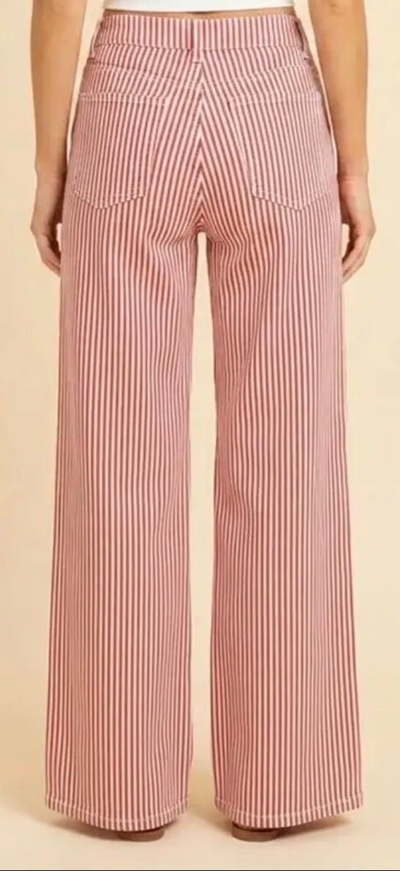 Red and white vertically striped wide-leg pants shown from the back on a model, against a solid beige background.