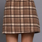 A brown and beige plaid mini skirt, shown on a model from the back against a solid gray background.