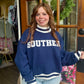 Navy blue Southern graphic sweatshirt with white striped trim, relaxed fit, and oversized sleeves styled with light wash jeans