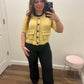 A woman takes a mirror selfie wearing a yellow short-sleeve knit cardigan with black buttons and trim, paired with black wide-leg pants. 