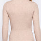 A woman shown from the back wearing a beige ribbed mock neck long-sleeve sweater and blue jeans against a plain white background.