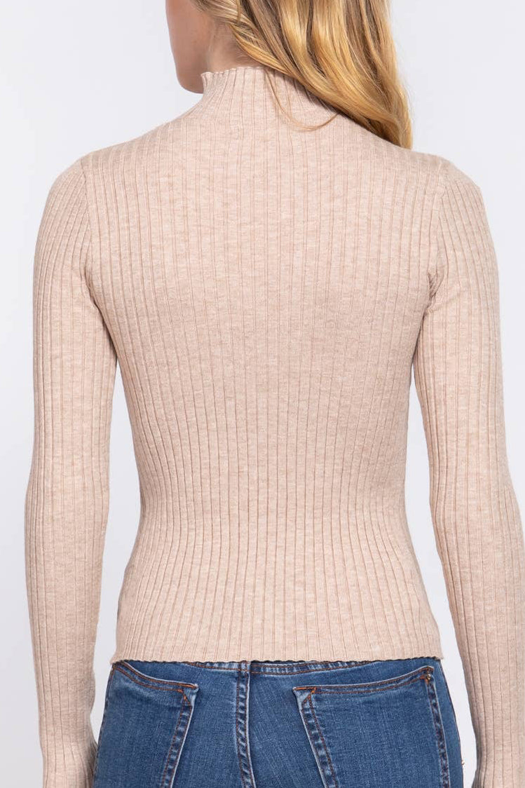 A woman shown from the back wearing a beige ribbed mock neck long-sleeve sweater and blue jeans against a plain white background.