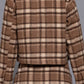 A woman shown from the back wearing a brown and beige plaid cropped jacket and matching mini skirt against a solid gray studio background.